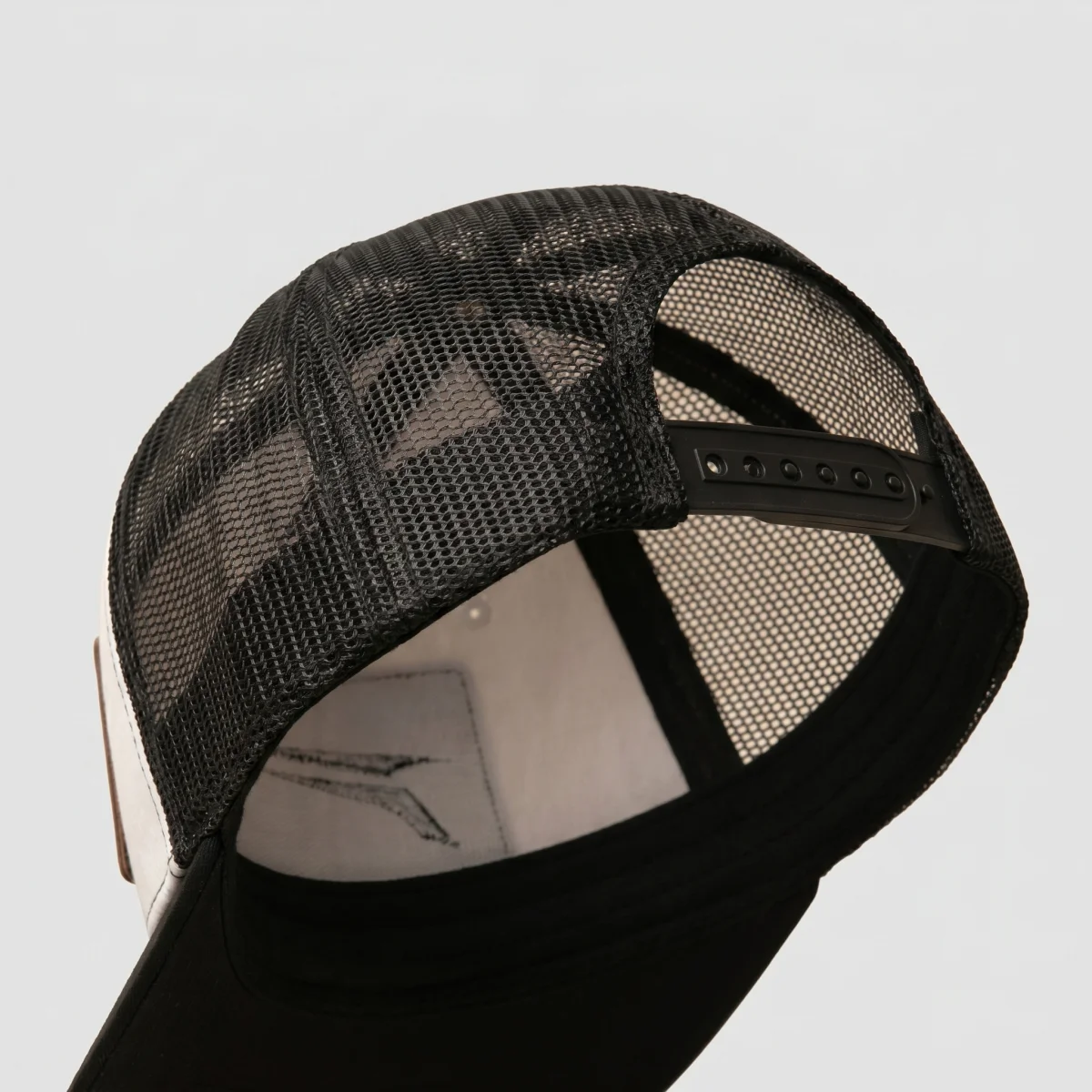 Four panel black mesh back of The Icon, three quarter rear angle showing snapback closure